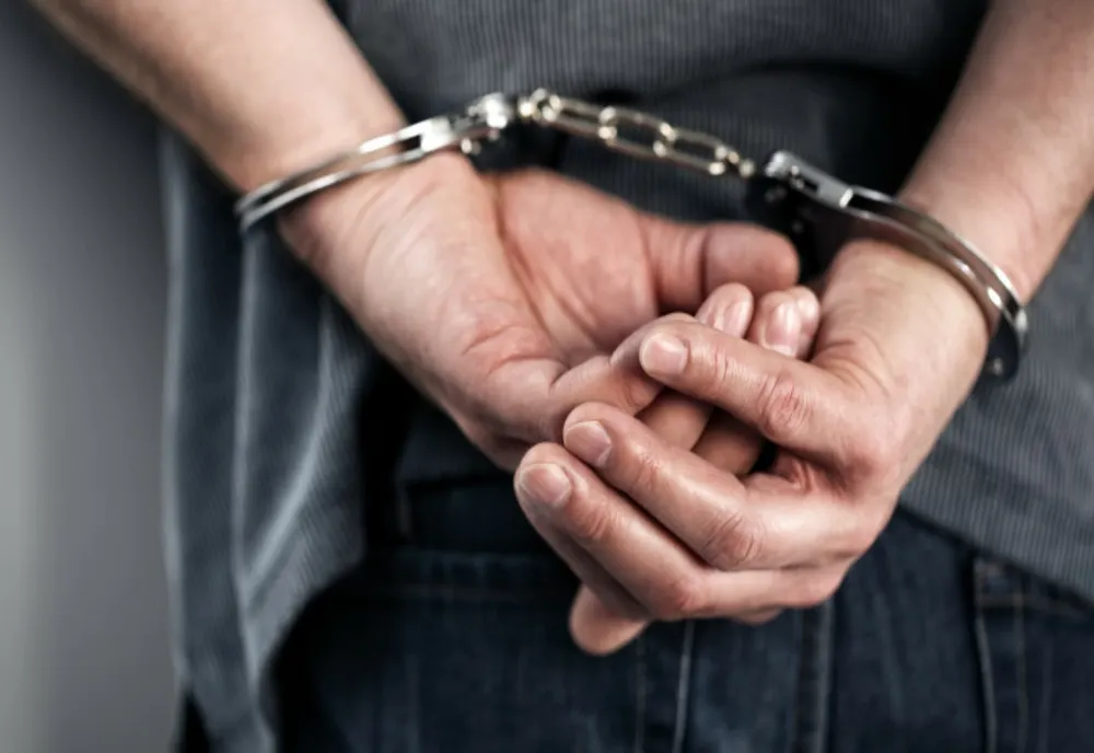 Două persoane, condamnate pentru luare de mită și cumpărare de influență, prinse de polițiști și duse în penitenciar